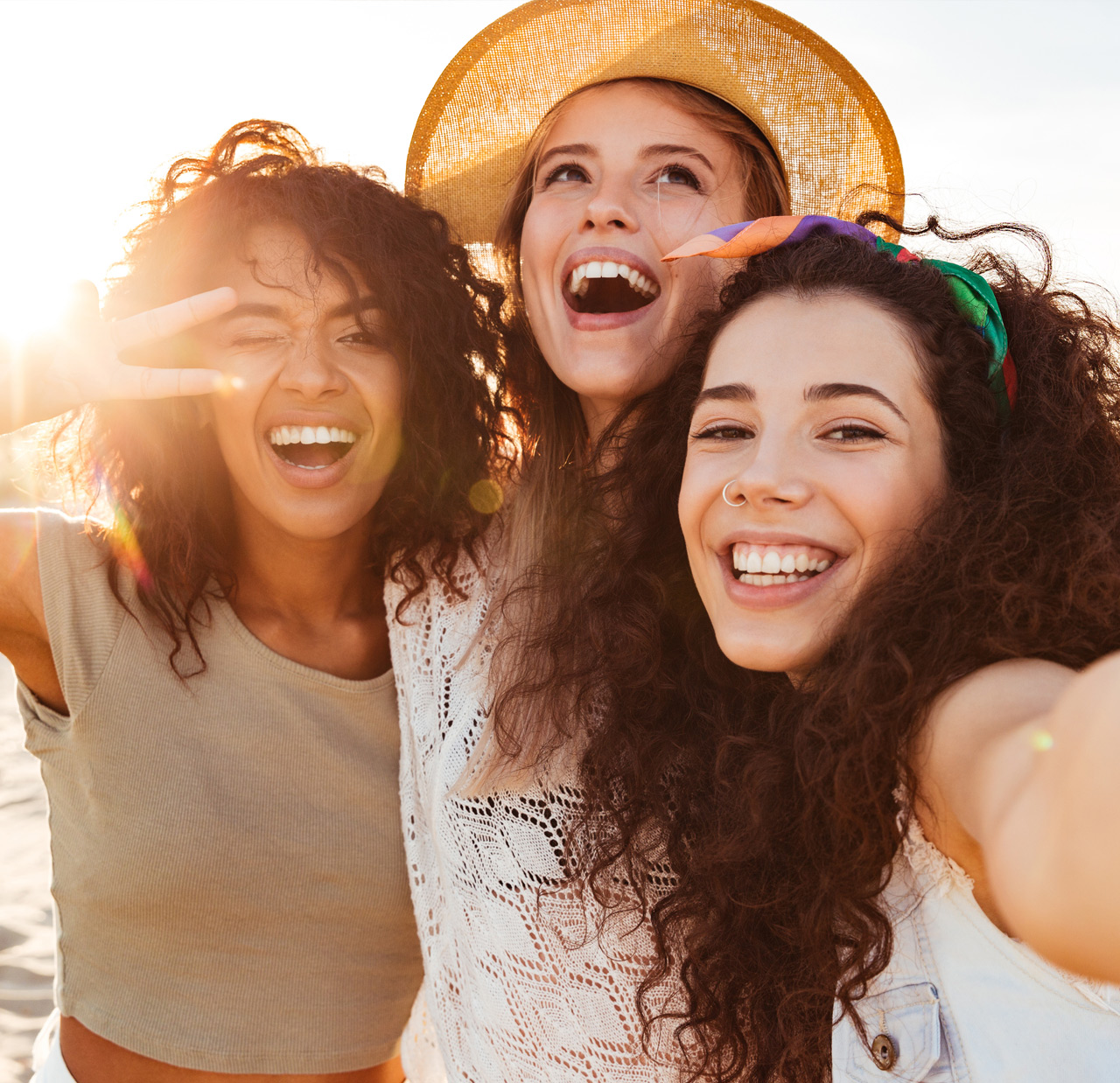 Three cheerful girls friends in summer clothes